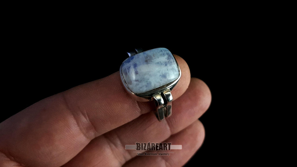 The artisan ring worn on a finger to provide a sense of scale and visual presence on the hand.