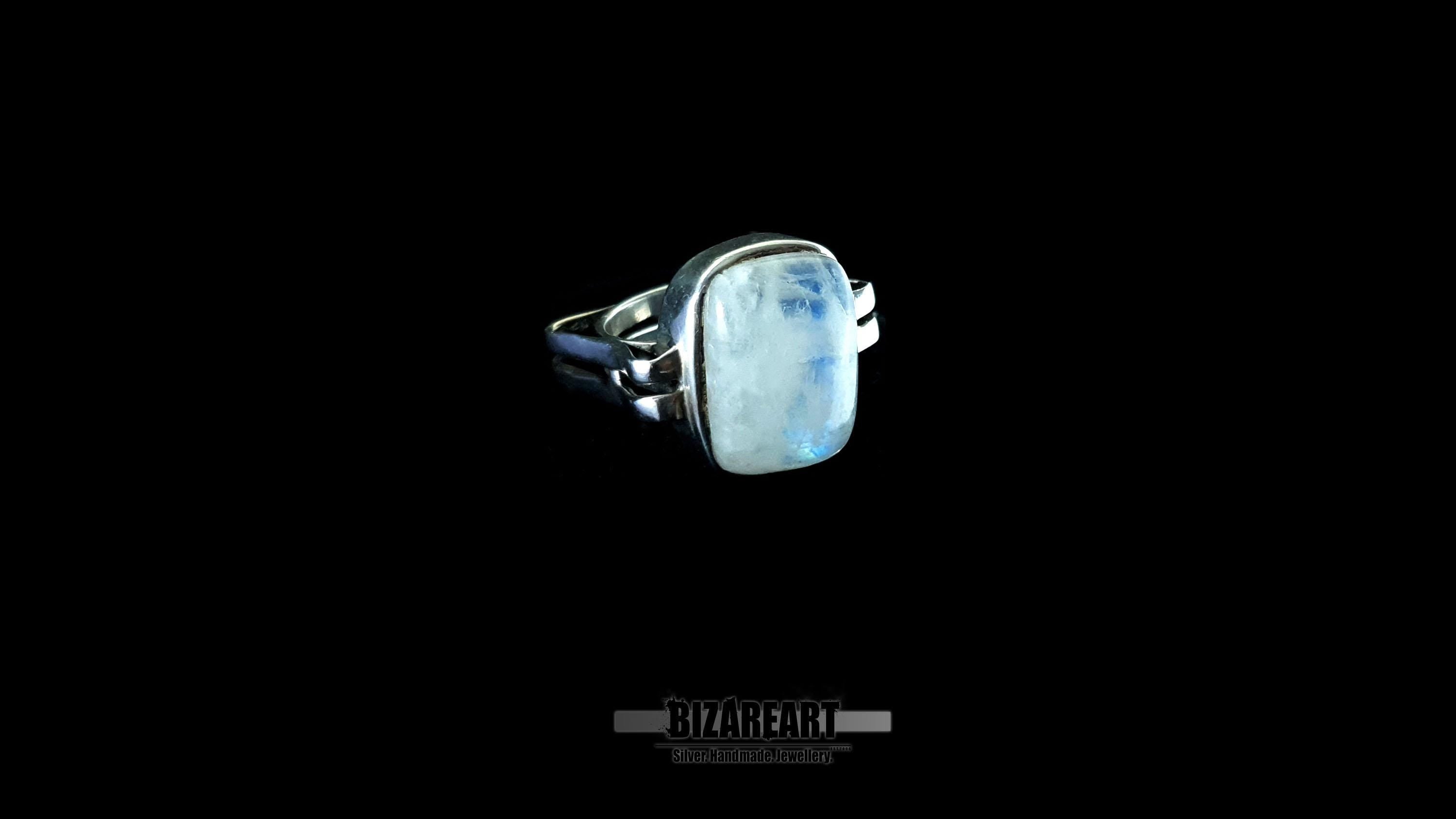 Profile view of a handcrafted sterling silver ring featuring a large, rectangular moonstone cabochon set in a sculptural, architectural frame against a black background.