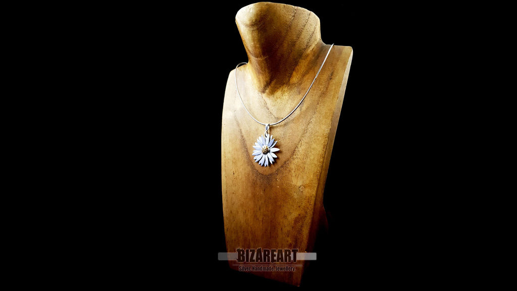 Three-quarter angle of the silver and gold daisy pendant, showcasing the high-luster finish and textured petal details.