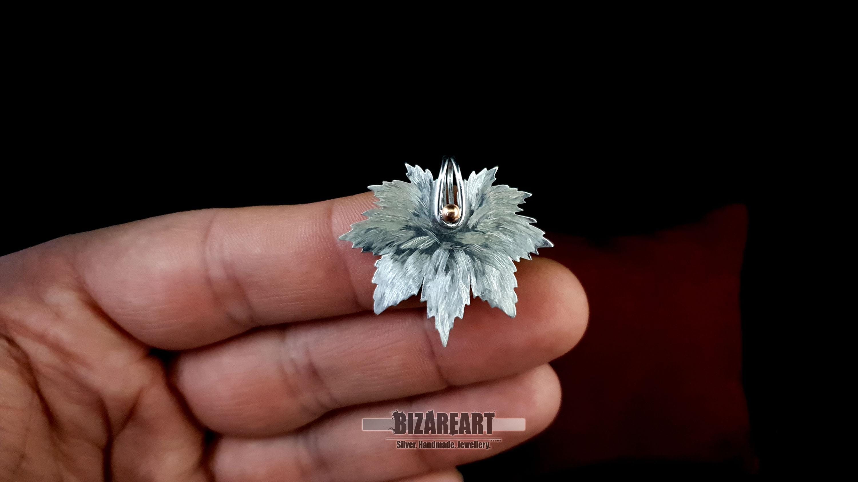 "Handheld view of the maple leaf pendant to demonstrate its 3.5cm scale and three-dimensional, lifelike thickness.