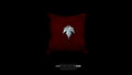 Top-down view of a hand-carved sterling silver leaf pendant resting on a plush red velvet cushion against a black background.