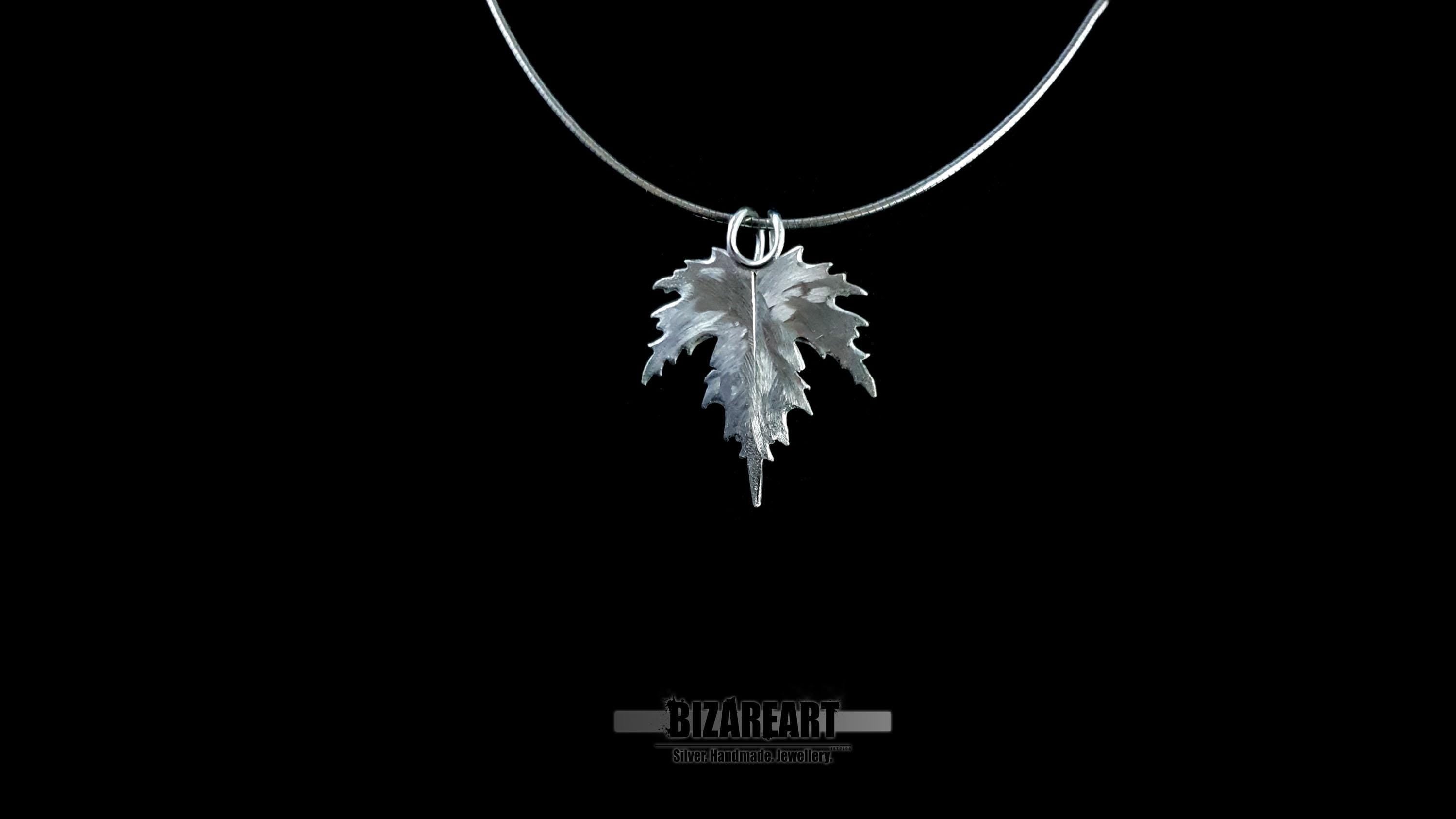 Sterling silver leaf pendant suspended from a thin silver neck wire, highlighting the seamless hidden bail design.