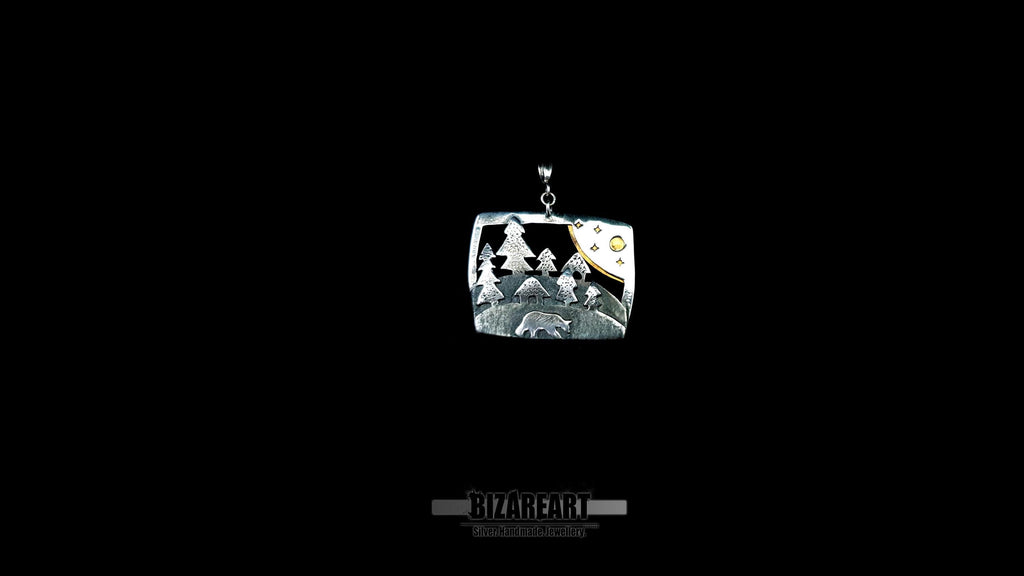 Front view of the artisan silver forest pendant centered on a black studio background, showcasing its detailed rectangular silhouette and modern hanger.