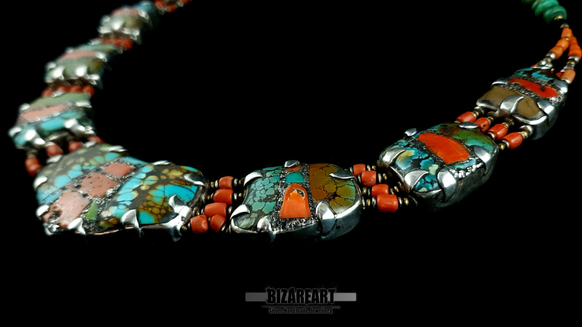 Detailed close up of turquoise and coral gemstone mosaic set in sterling silver plates