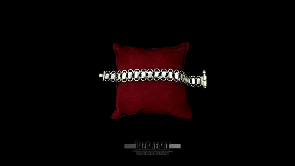 Smooth, mirror-polished reverse side of the Bizareart Byzantium sterling silver link bracelet displayed on a red velvet pillow.