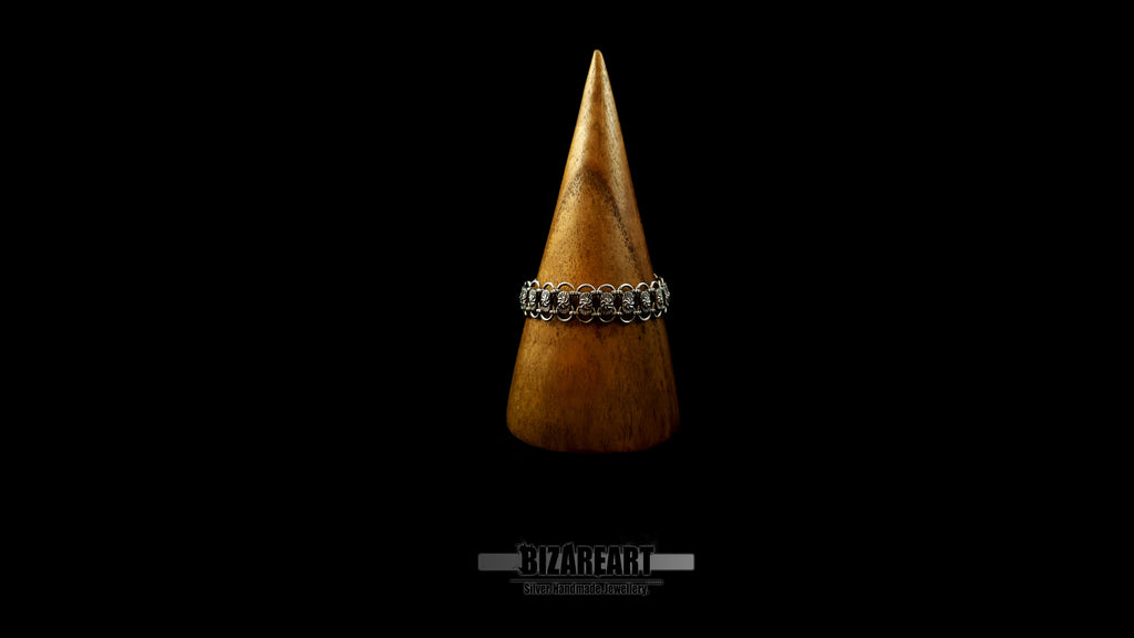 Front view of the Bizareart Byzantium sterling silver link bracelet styled around a rustic, conical wooden display stand against a black background.