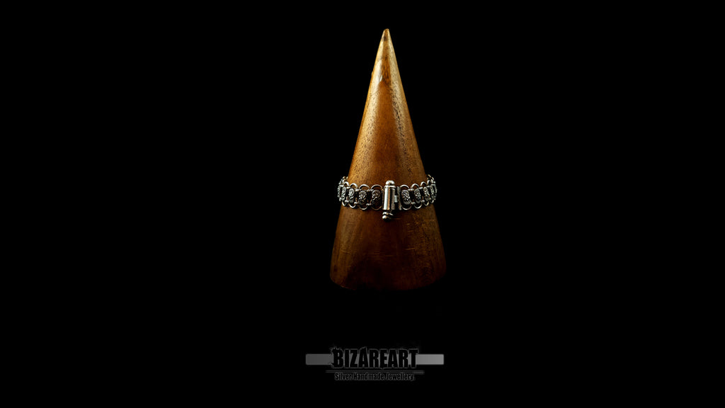 Rear view of the Bizareart silver link bracelet on a wooden cone display, highlighting the seamless integration of the custom barrel and safety pin closure.