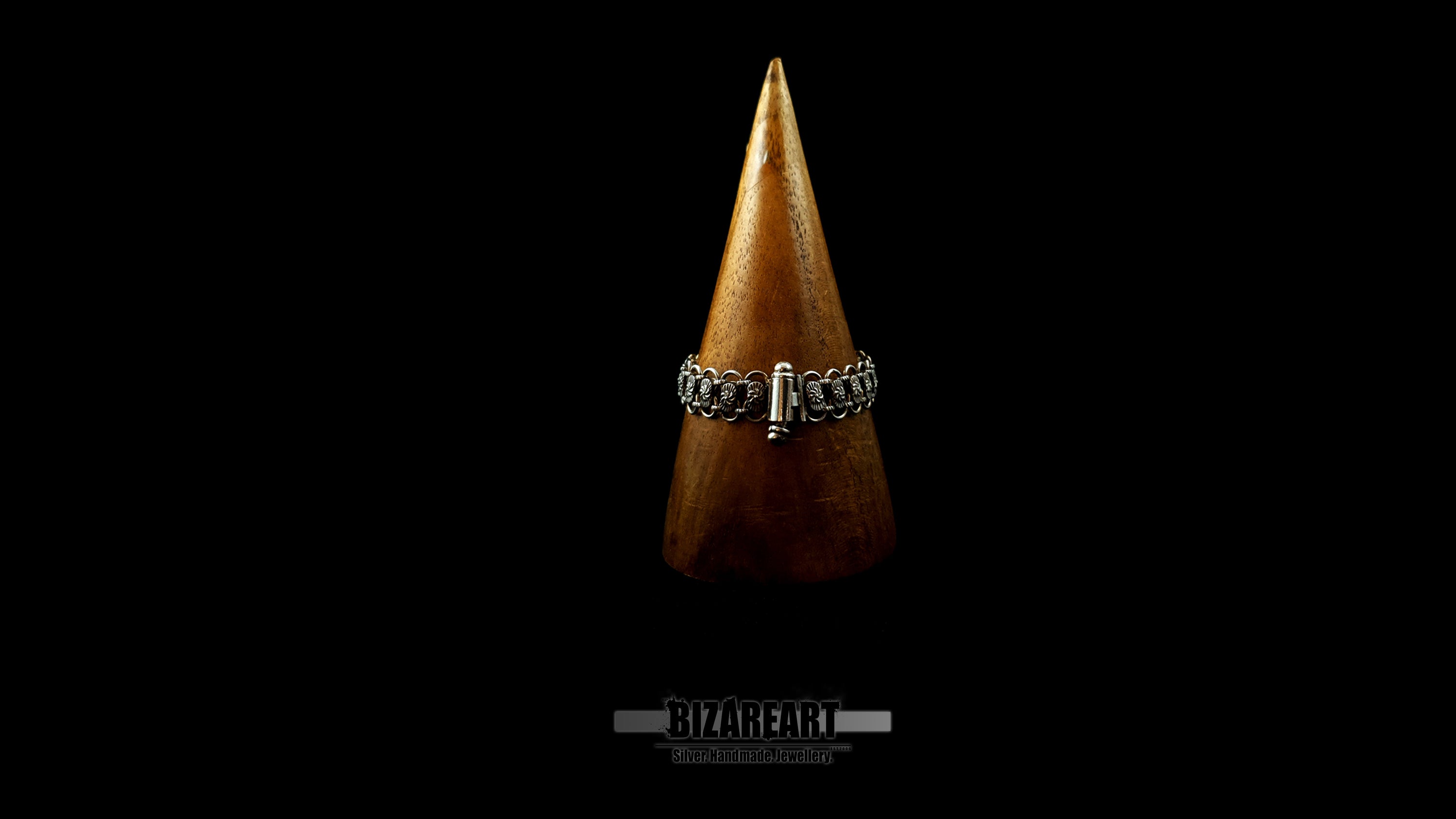 Rear view of the Bizareart silver link bracelet on a wooden cone display, highlighting the seamless integration of the custom barrel and safety pin closure.