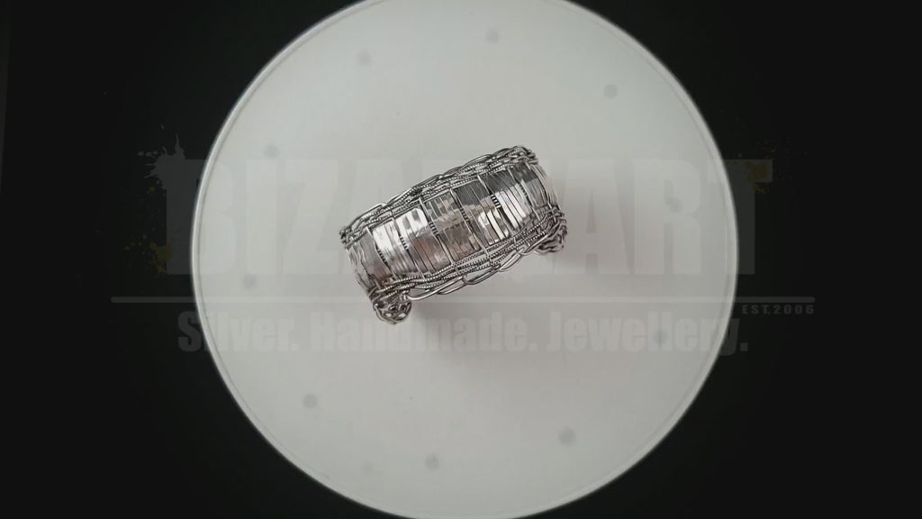 Product video demonstrating how to easily slide the adjustable multilayered silver bracelet onto the wrist and showing the metal's brilliant catch of light under motion.