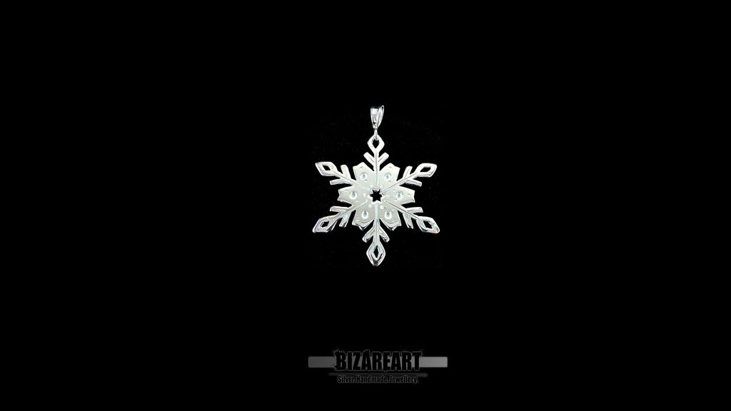 A high-contrast shot of the silver snowflake pendant against a solid black background, highlighting the reflective rhodium finish and transparent enamel work.